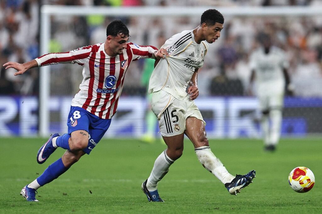 Real Madrid's Spanish defender #18 Alvaro Carreras fights for the ball with Real Madrid's English midfielder #05 Jude Bellingham during the Spanish Supercup semi-final football match between Atletico Madrid and Real Madrid at King Abdullah Sports City�in Jeddah on January 8, 2026. (Photo by Fadel SENNA / AFP)