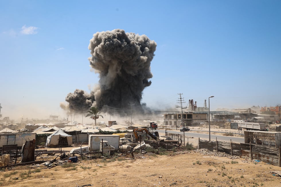 El humo negro se eleva tras las tiendas de campaña que albergan a familias palestinas desplazadas internamente tras un ataque de Israel en Gaza, el 23 de agosto de 2026. (Foto de Eyad Baba / AFP).