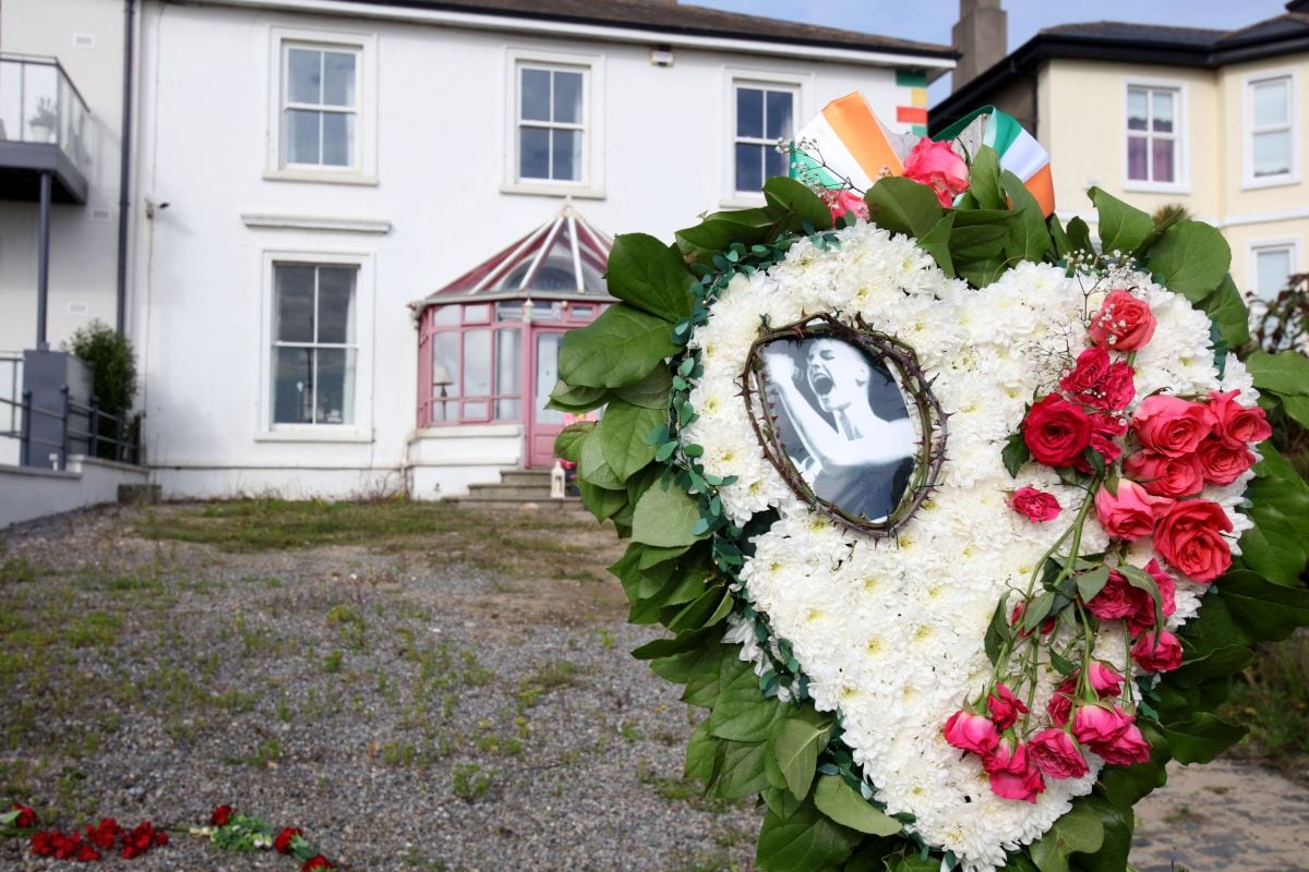 Las flores y los tributos se muestran fuera de la antigua casa de la cantante irlandesa Sinead O'Connor, en Bray, en el este de Irlanda, antes de su funeral el 8 de agosto de 2023 (Foto: Paul Faith / AFP)