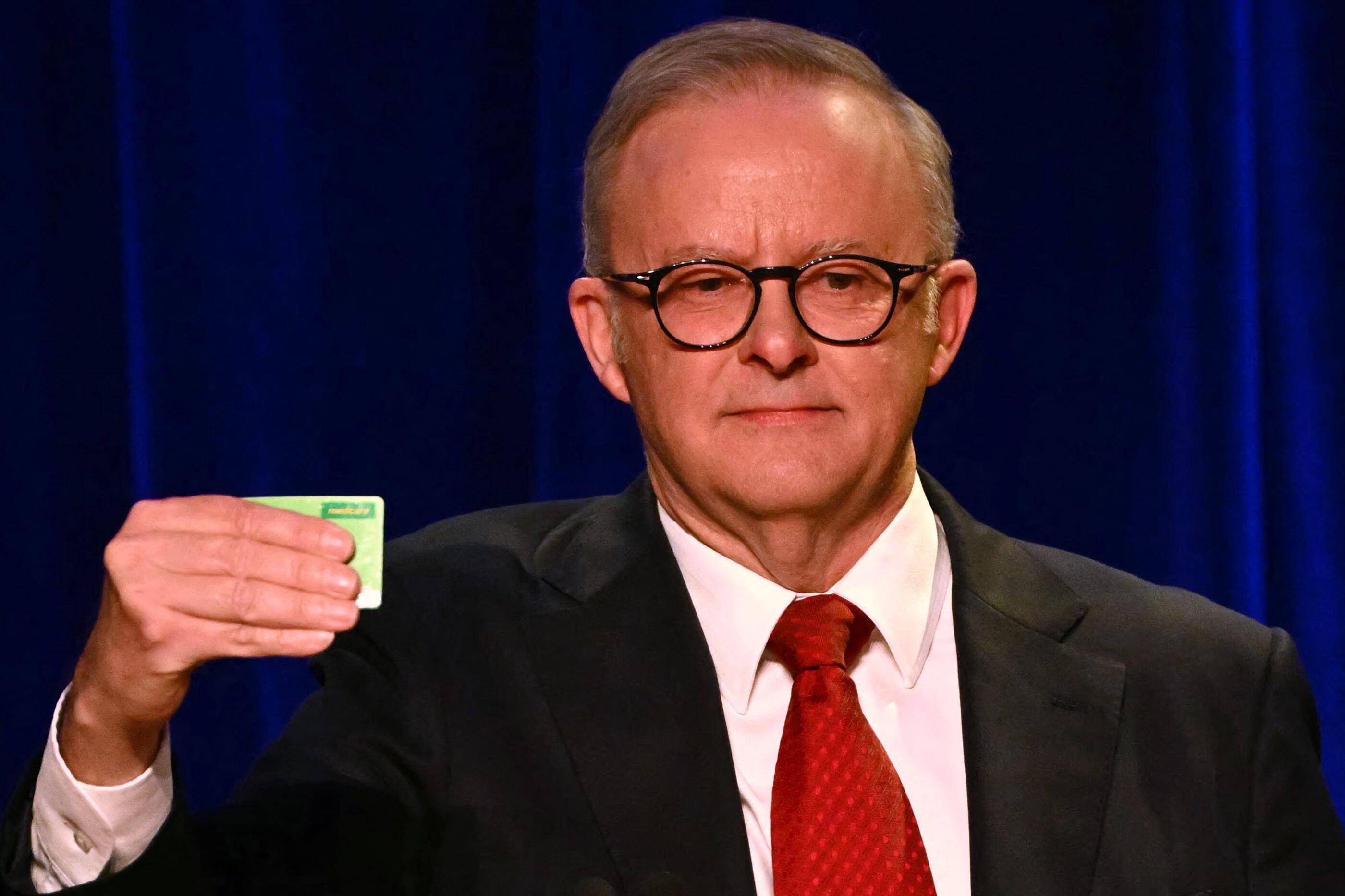 El primer ministro australiano, Anthony Albanese, sostiene su tarjeta de Medicare tras ganar las elecciones generales en el evento de la noche electoral del Partido Laborista en Sídney el 3 de mayo de 2025. (Foto de Saeed KHAN / AFP)