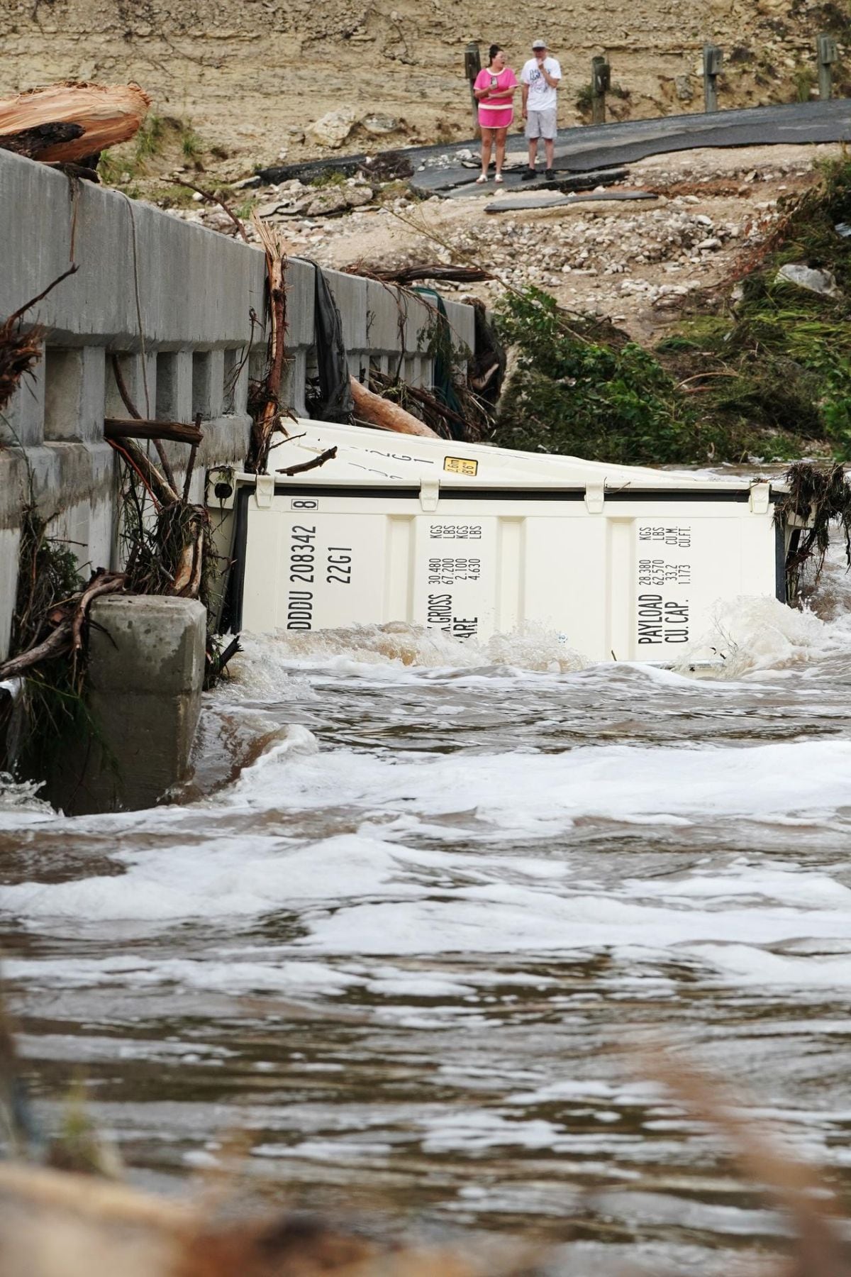 La Mystic Alerts Act apunta a que, durante inundaciones u otros desastres, las comunidades rurales y zonas con mala cobertura móvil sigan recibiendo avisos críticos gracias a un respaldo satelital. En la imagen, varias personas observan el paso de escombros por el río Guadalupe en Kerrville, Texas, el 16 de julio (Foto: EFE / EPA / Dustin Safranek)