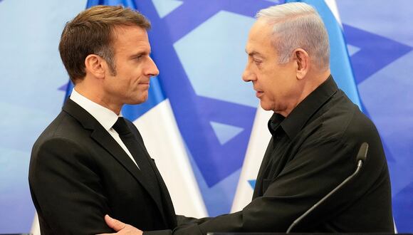 El primer ministro israelí, Benjamin Netanyahu, le da la mano al presidente francés, Emmanuel Macron, después de su conferencia de prensa conjunta en Jerusalén el 24 de octubre de 2023. (Foto de Christophe Ena / POOL / AFP)