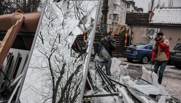 Ventanas rotas son llevadas a un punto de recogida de basura cerca del sitio de un edificio residencial dañado tras un ataque con misiles en Kiev (Kiev), Ucrania, el 13 de diciembre de 2023, en medio de la invasión rusa. EFE/EPA/OLEG PETRASYUK