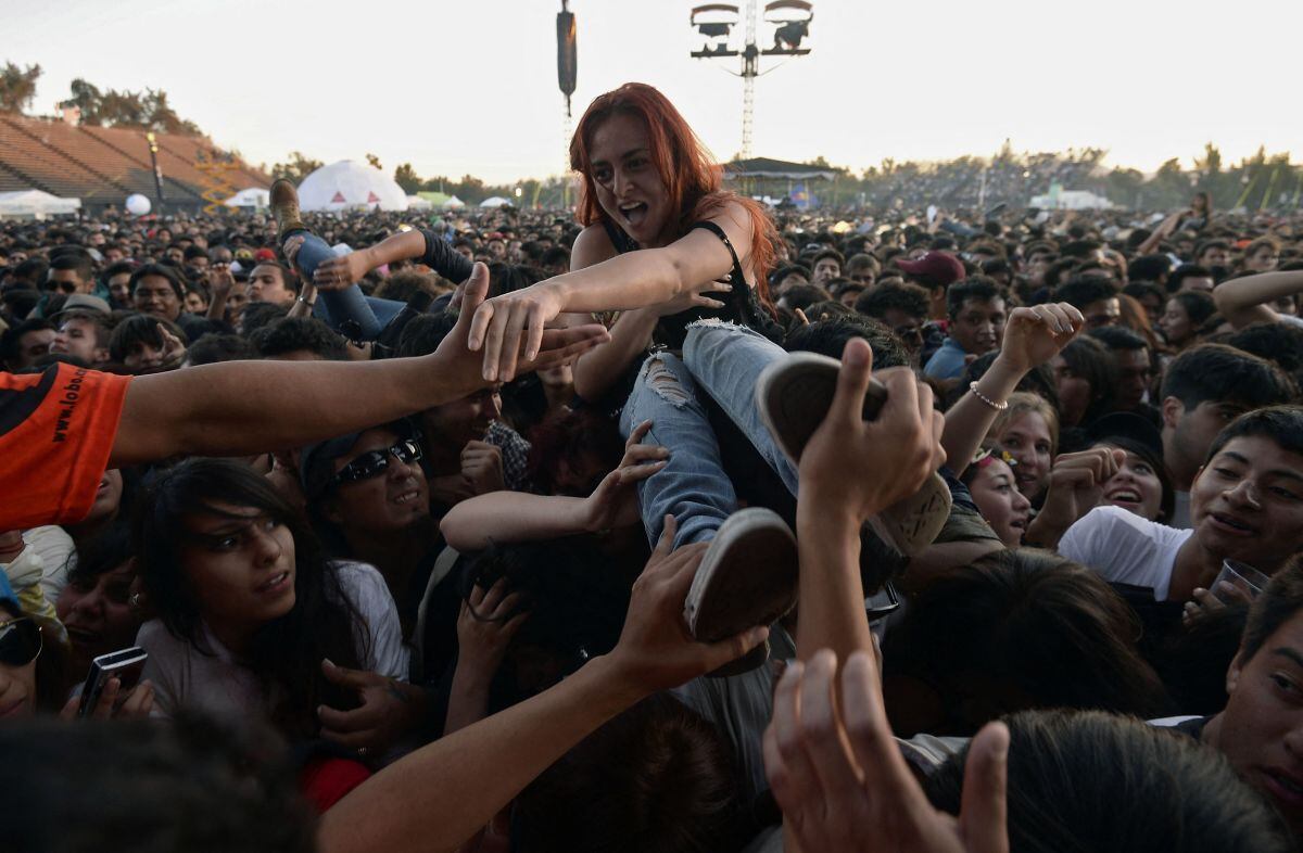 Una mujer es auxiliada por un personal de seguridad durante el segundo día del Corona Capital Music Fest en el hipódromo Hermanos Rodríguez, en la Ciudad de México, el 13 de octubre de 2013 (Foto: Alfredo Estrella / AFP)