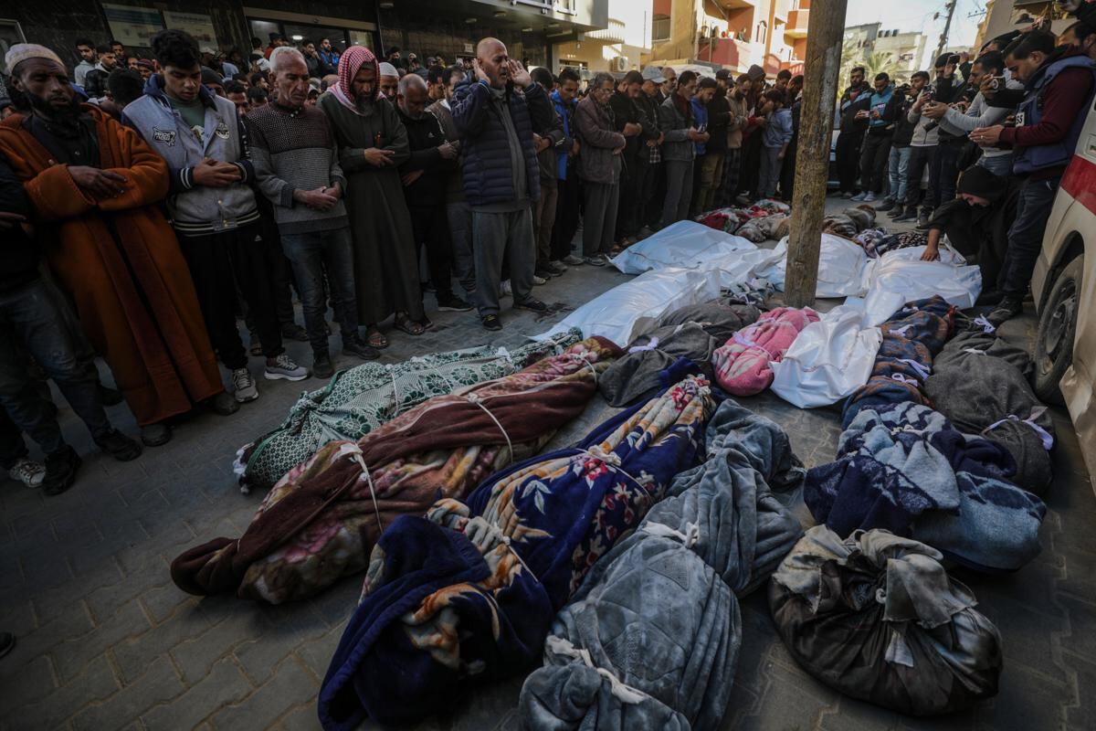 Palestinos rezan junto a los cuerpos cubiertos de los muertos después de un ataque aéreo israelí, durante su funeral en el campo de refugiados de Al Nuseirat, en el centro de la Franja de Gaza, el 13 de diciembre de 2024. (Foto de EFE/EPA/MOHAMMED SABER)
