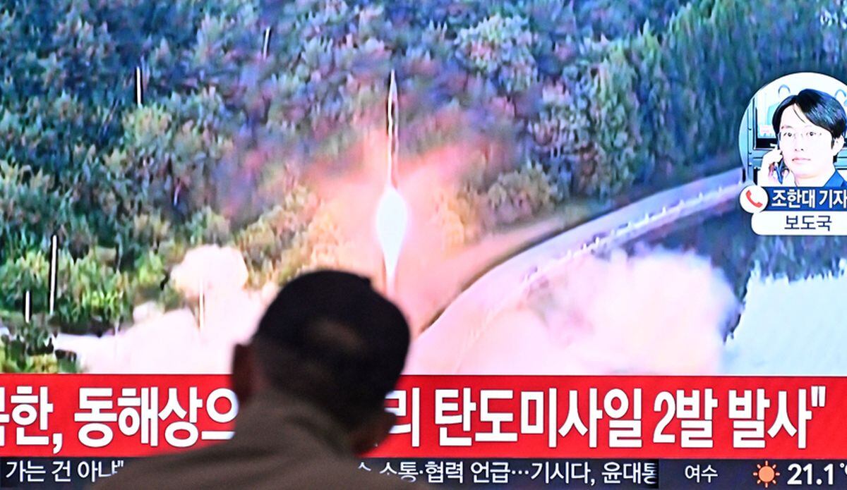 Un hombre mira un televisor que muestra una transmisión de noticias con imágenes de archivo de una prueba de misiles de Corea del Norte, en una estación de tren en Seúl el 15 de junio de 2023 (Anthony WALLACE / AFP)