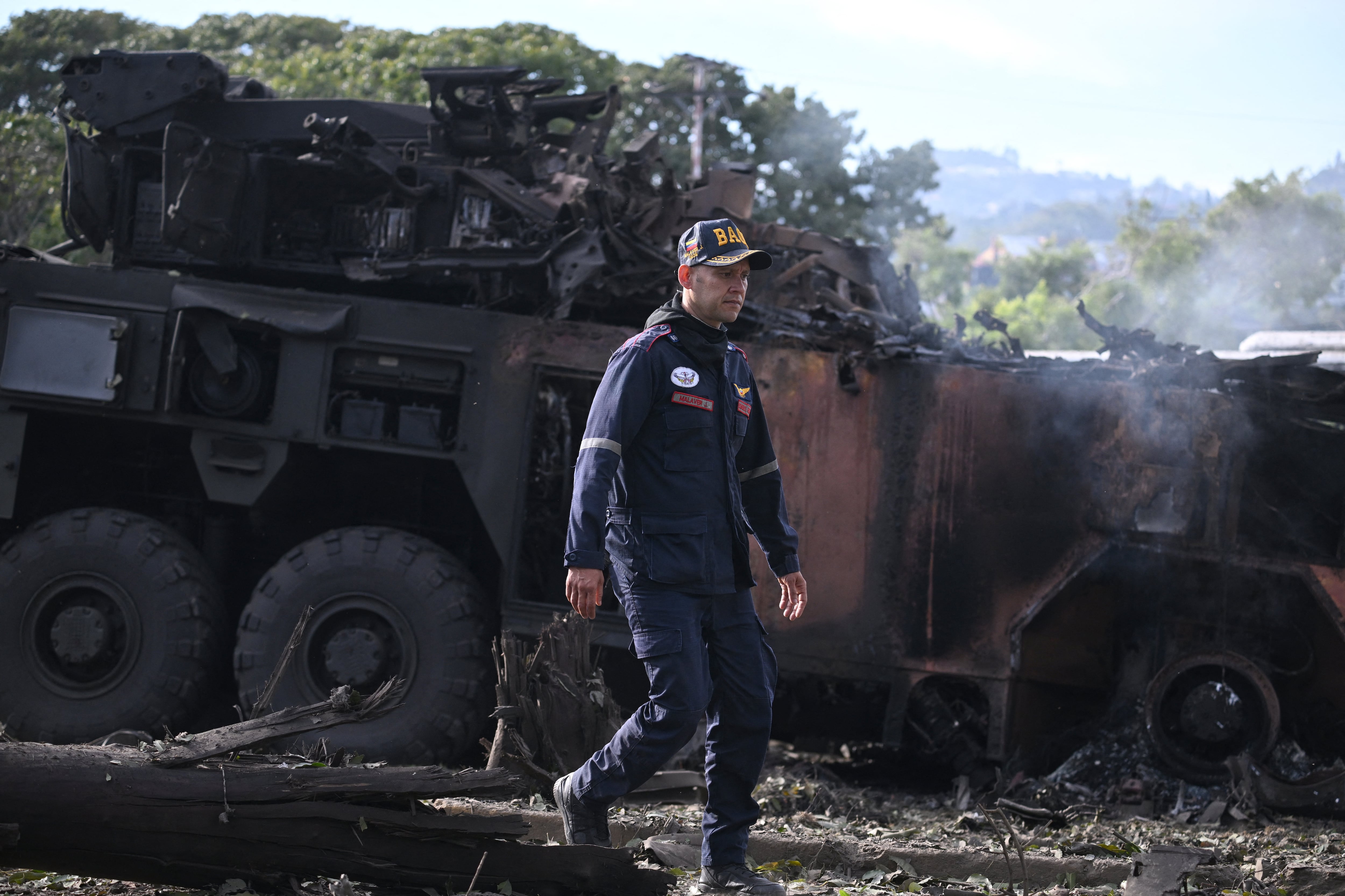 Un bombero pasa junto a un vehículo militar incendiado en la base aérea La Carlota de Caracas el 3 de enero de 2026. (Foto de Federico PARRA / AFP).