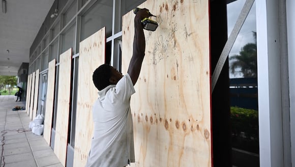 Un trabajador tapa una ventana del edificio de la Corporación de Desarrollo Urbano en Kingston, Jamaica, antes de la llegada del huracán Beryl, el 3 de julio de 2024. (Foto de Ricardo Makyn / AFP)