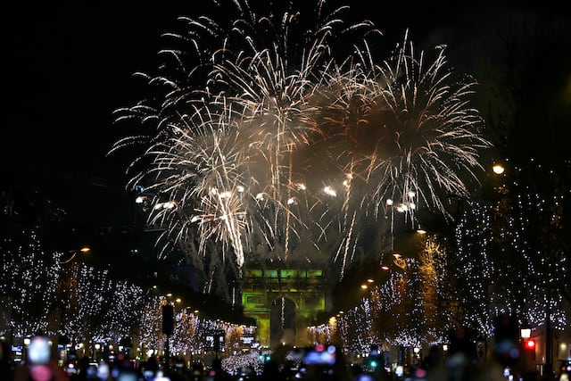 Los fuegos artificiales estallan en el cielo sobre el Arco del Triunfo, en la Place de l'Etoile, en el centro de París. (Foto de Alain JOCARD / AFP).