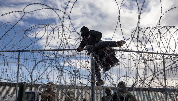 Un migrante de Venezuela trepa una valla fronteriza en un intento de ingresar y buscar asilo en El Paso, Texas. (Foto de CRISTIAN MONTERROSA/AFP)