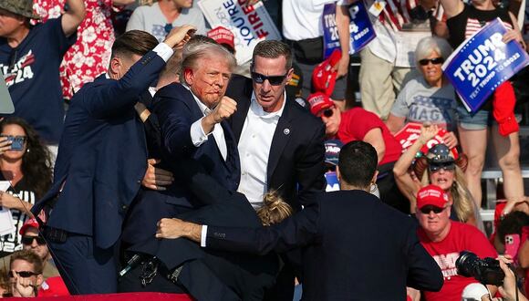 El candidato republicano Donald Trump con sangre en el rostro rodeado de agentes del servicio secreto en un evento de campaña en Butler Farm Show Inc. en Butler, Pensilvania, el 13 de julio de 2024. (Foto de Rebecca DROKE / AFP)