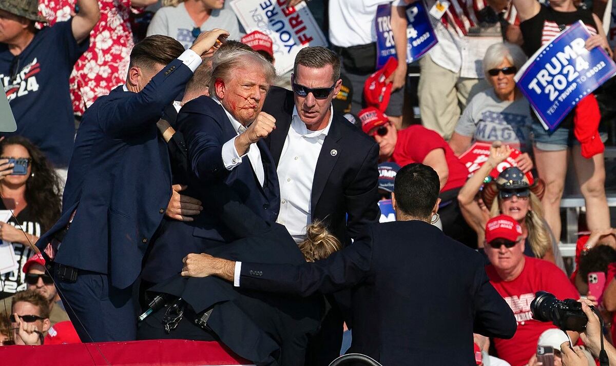 El candidato republicano Donald Trump con sangre en el rostro rodeado de agentes del servicio secreto en un evento de campaña en Butler Farm Show Inc. en Butler, Pensilvania, el 13 de julio de 2024. (Foto de Rebecca DROKE / AFP)
