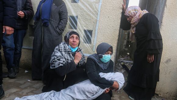 Familiares lloran junto a un cuerpo envuelto después de que un ataque aéreo israelí impactara la casa de la familia Baraka en Deir al-Balah, en el centro de la Franja de Gaza, el 18 de febrero de 2024, en medio de batallas en curso entre Israel y el grupo militante palestino Hamas en el territorio palestino sitiado. (Foto de AFP)