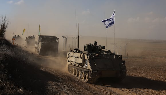 Un convoy de vehículos militares israelíes circula por una carretera en un lugar no revelado en la frontera con la Franja de Gaza el 15 de octubre de 2023. (Foto de Menahem KAHANA / AFP).