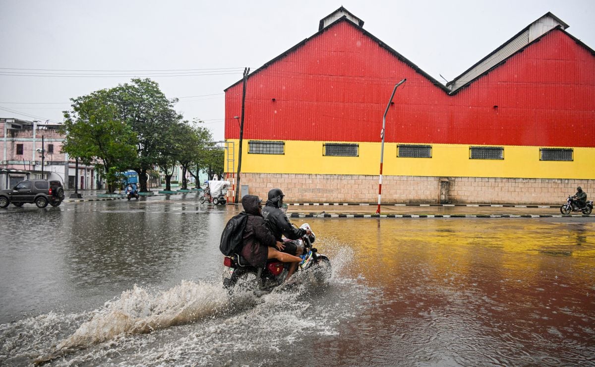 Residentes recorren en motocicleta las zonas inundadas antes del paso del huracán Melissa por la ciudad de Santiago de Cuba, Cuba, el 28 de octubre de 2025 (Foto: Yamil Lage / AFP)