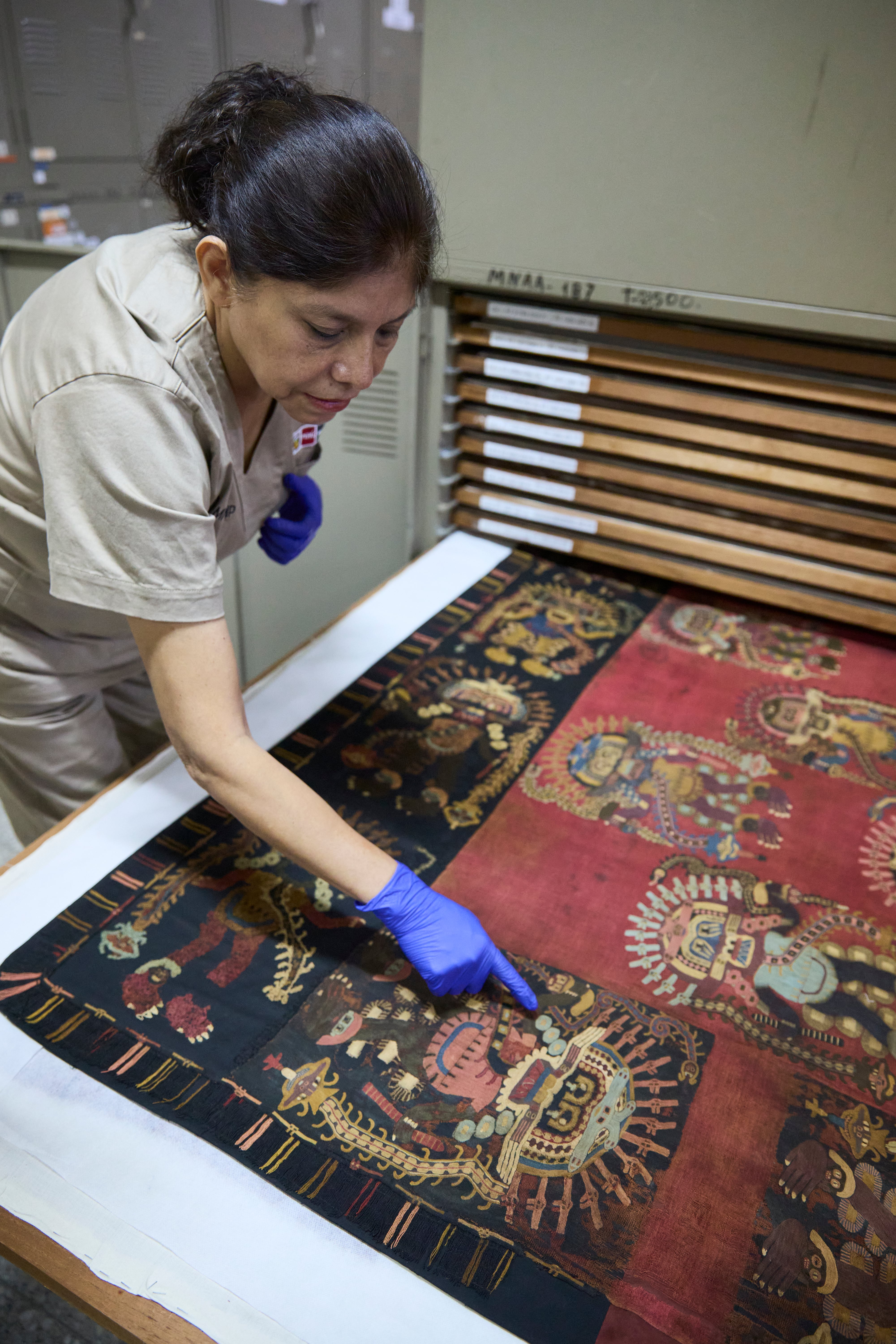 La arqueóloga, conservadora y especialista en textiles, María Ysabel Medina nos guía por las instalaciones del MNAAHP. Aquí se resguarda la mayor parte de la colección paracas. Esta incluye 429 fardos y más de 200 mantos en sus anaqueles.