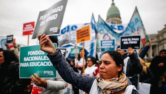 Una manifestante sostiene un cartel con consignas durante una protesta en la Plaza del Congreso, este jueves en Buenos Aires. Foto: Juan Ignacio Roncoroni/EFE