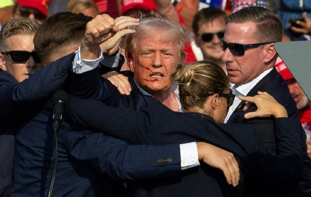El candidato republicano Donald Trump con sangre en el rostro rodeado de agentes del servicio secreto en un evento de campaña en Butler Farm Show Inc. en Butler, Pensilvania, el 13 de julio de 2024. (Foto de Rebecca DROKE / AFP)
