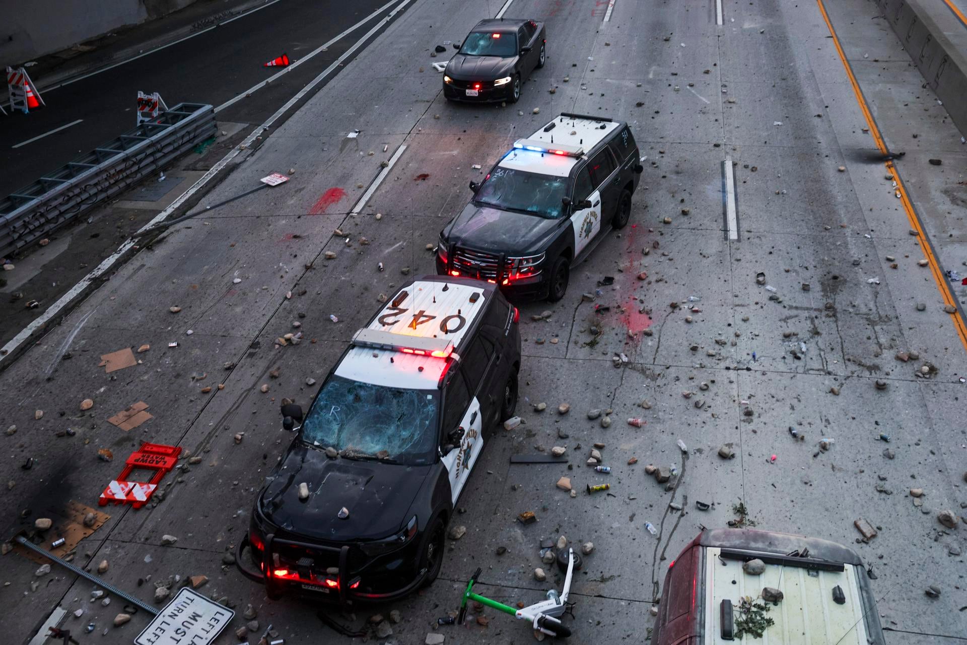 Vehículos policiales abandonados son apedreados por activistas durante las protestas en Los Ángeles, California. (EFE/EPA/ALLISON DINNER).