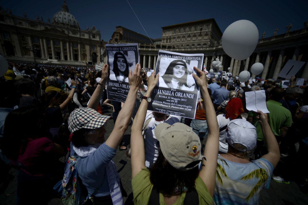 Los manifestantes sostienen carteles de Emanuela Orlandi leyendo "Missing" durante la oración del mediodía del Regina Coeli del Papa Benedicto XVI en la plaza de San Pedro, en el Vaticano el 27 de mayo de 2012 (Foto: Filippo Monteforte / AFP)