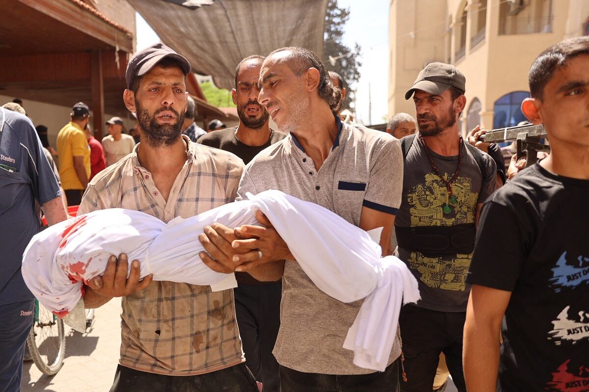 Palestinos transportan un cuerpo durante un funeral tras un ataque israelí contra una escuela que alberga a palestinos desplazados en el barrio de Zaytoun, de la ciudad de Gaza, el 21 de septiembre de 2024. (Foto de Omar AL-QATTAA / AFP)