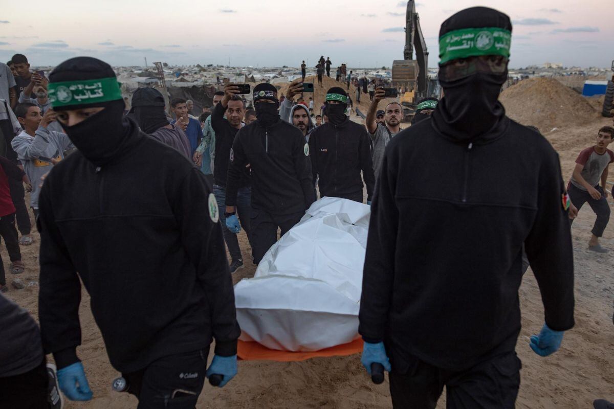 Militantes de Hamás transportan una bolsa blanca con un cadáver tras recuperarlo de un túnel en Jan Yunis, al sur de Gaza, el 28 de octubre de 2025. Foto: EFE/EPA/HAITHAM IMAD