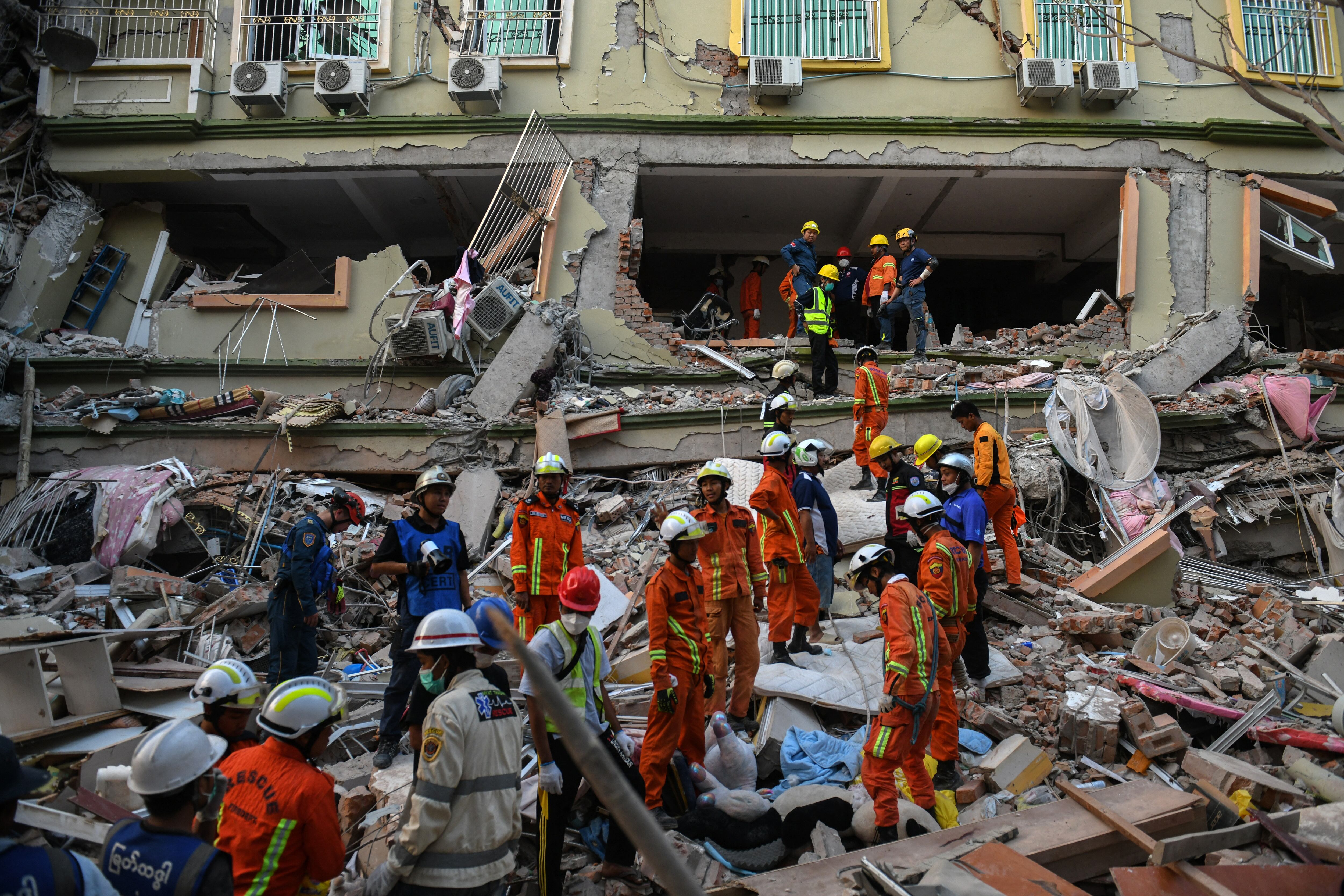 Equipos de rescate trabajan para evacuar a los residentes atrapados bajo los escombros del edificio derrumbado en Mandalay, Myanmar, el 30 de marzo de 2025. (Foto de Sai Aung MAIN / AFP).