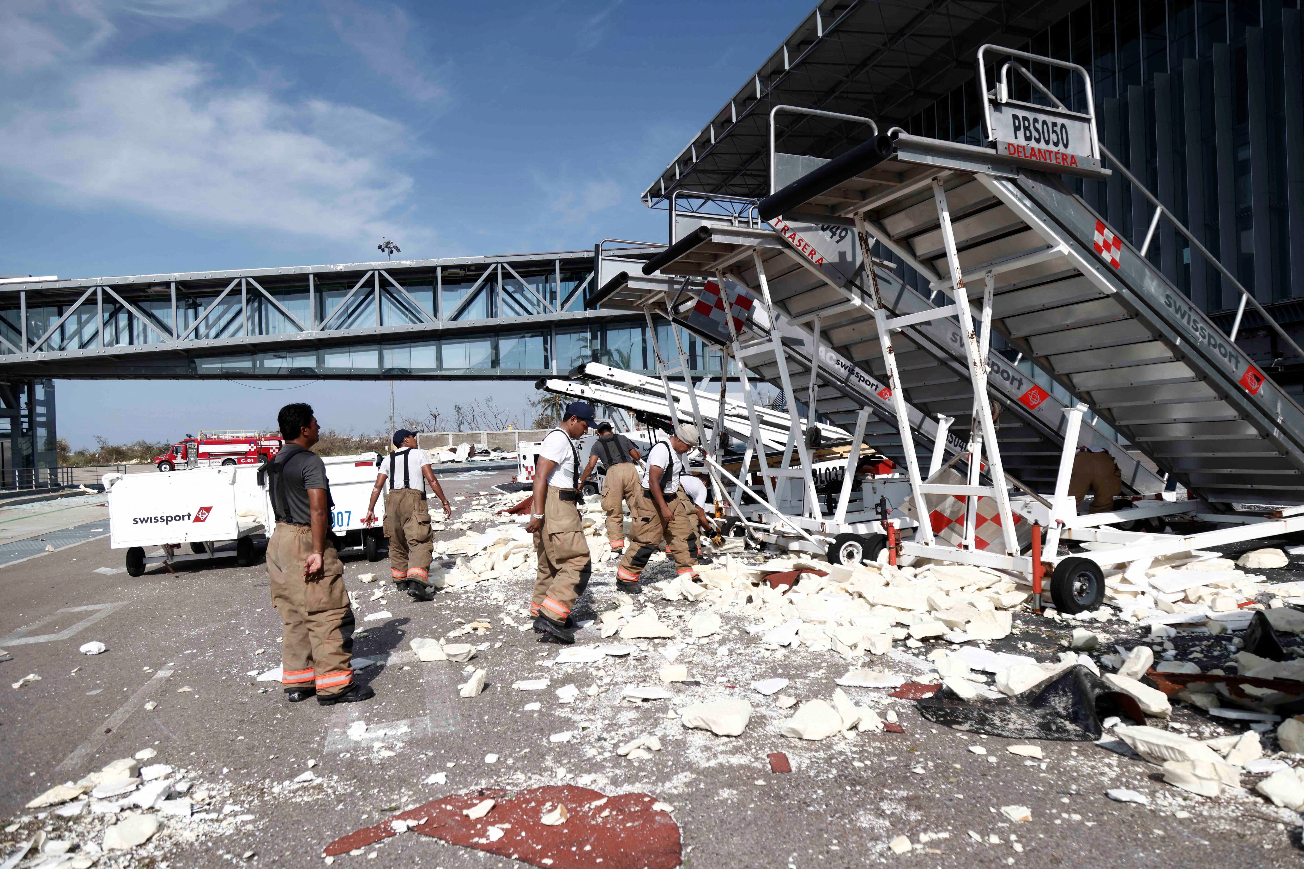 Miembros del Ejército retiran los escombros dejados por el paso del huracán Otis en el Aeropuerto Internacional de Acapulco. (Foto de Rodrigo OROPEZA/AFP).