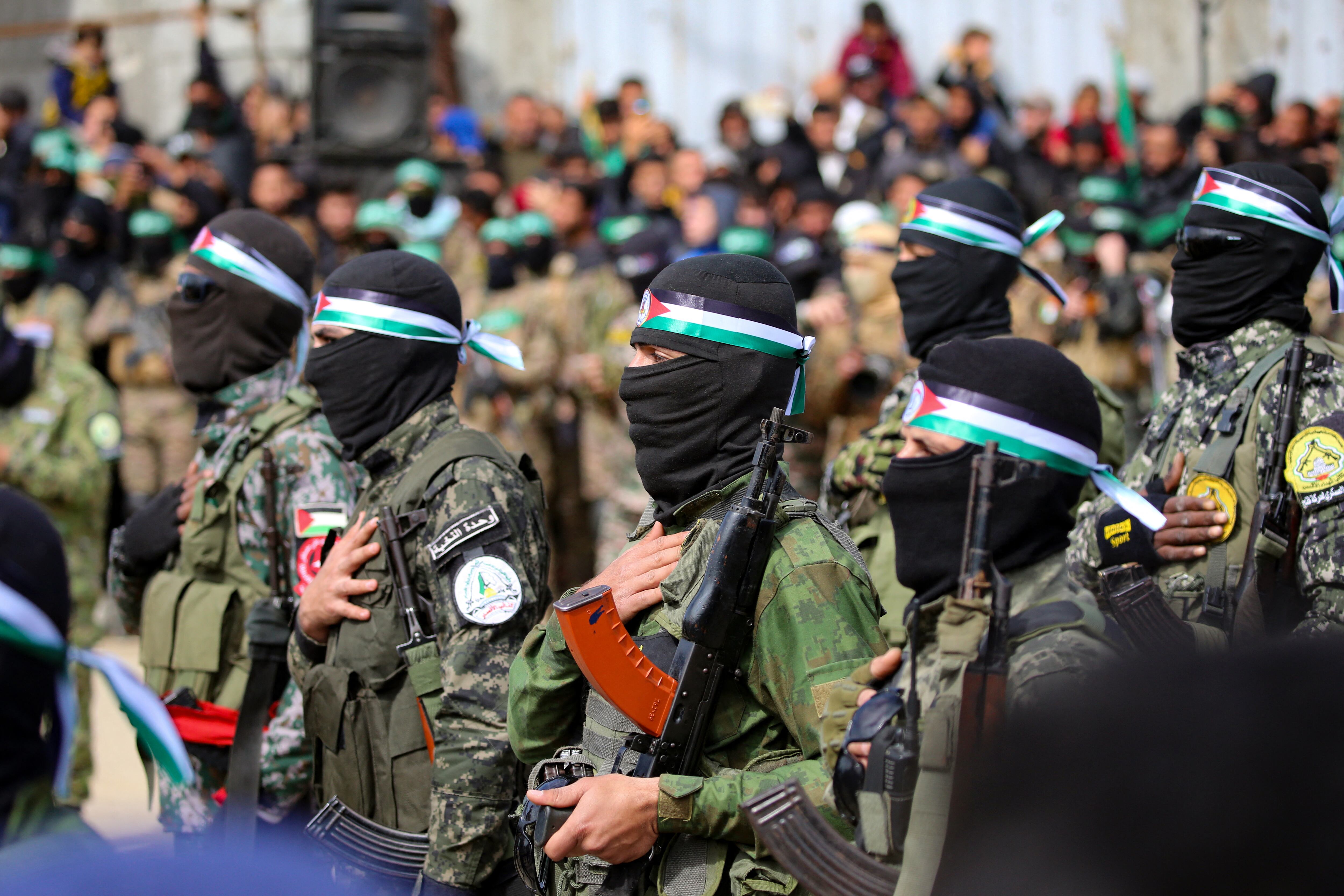 Palestinos y combatientes de Hamas se reúnen poco antes de la liberación de tres rehenes israelíes como parte del séptimo intercambio de rehenes por prisioneros, en Nuseirat, en el centro de la Franja de Gaza, el 22 de febrero de 2025. (Foto de Eyad BABA / AFP)