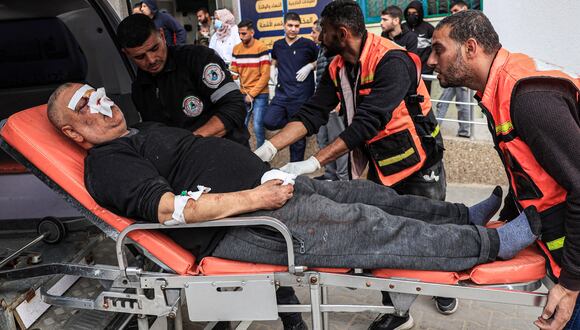 os paramédicos atienden a un hombre herido durante el bombardeo israelí cuando llega al Hospital Kuwait en Rafah, en el sur de la Franja de Gaza, el 20 de diciembre de 2023, en medio de batallas en curso entre Israel y el grupo militante palestino Hamás. (Foto de SAID KHATIB / AFP)