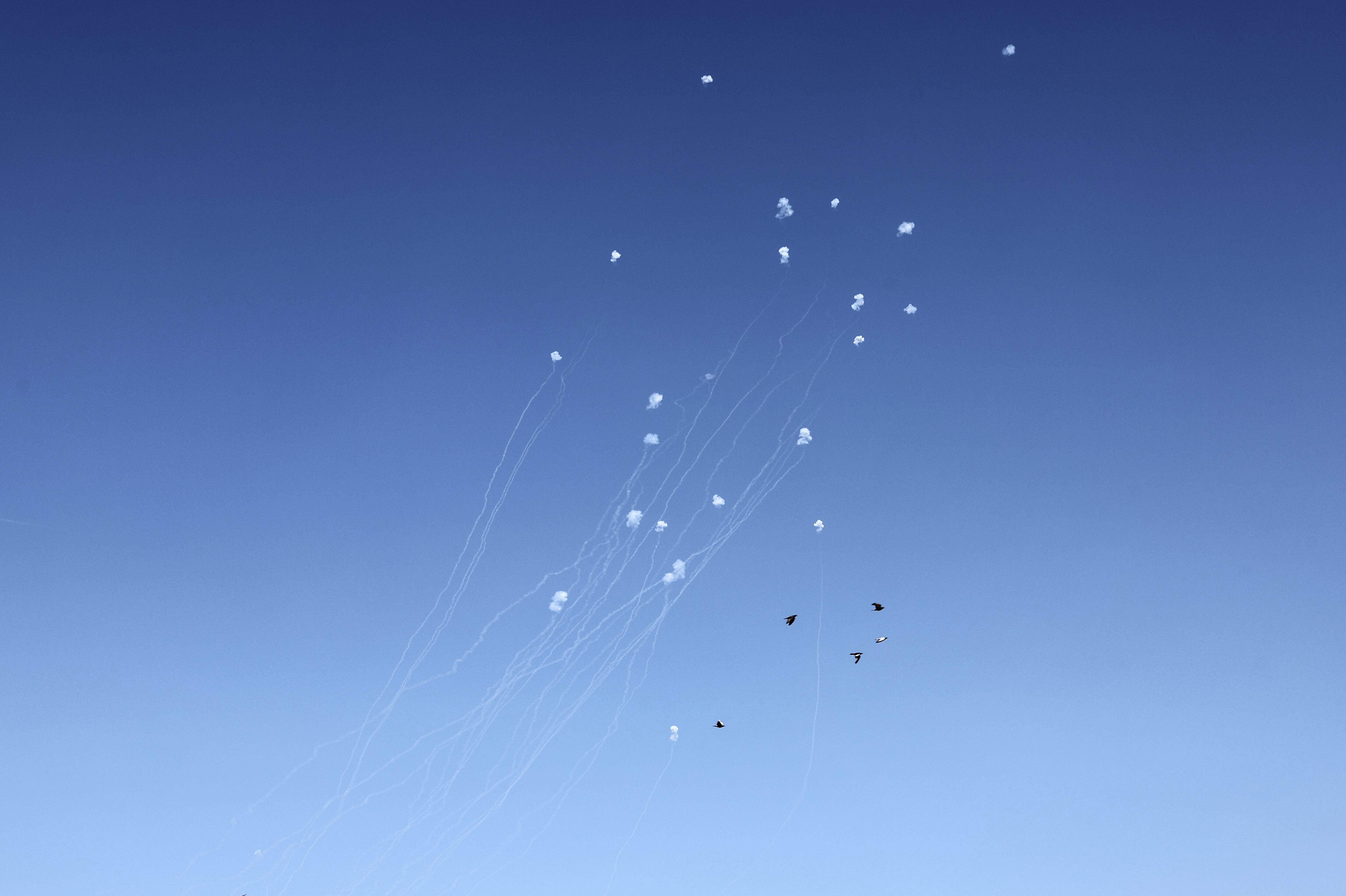 Los pájaros vuelan mientras el sistema de defensa antimisiles Cúpula de Hierro de Israel intercepta cohetes disparados desde el Líbano en el distrito de Haifa el 19 de octubre de 2024, en medio de la guerra en curso entre Israel y Hezbolá. (Foto de Jack GUEZ / AFP)