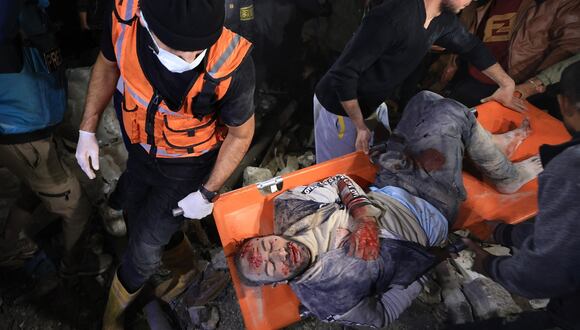 Rescatistas se llevan a un hombre herido después de ser sacado de debajo de los escombros de un edificio golpeado por un ataque israelí en Rafah, en el sur de la Franja de Gaza, el 28 de diciembre de 2023. (Foto de Mahmud HAMS / AFP)