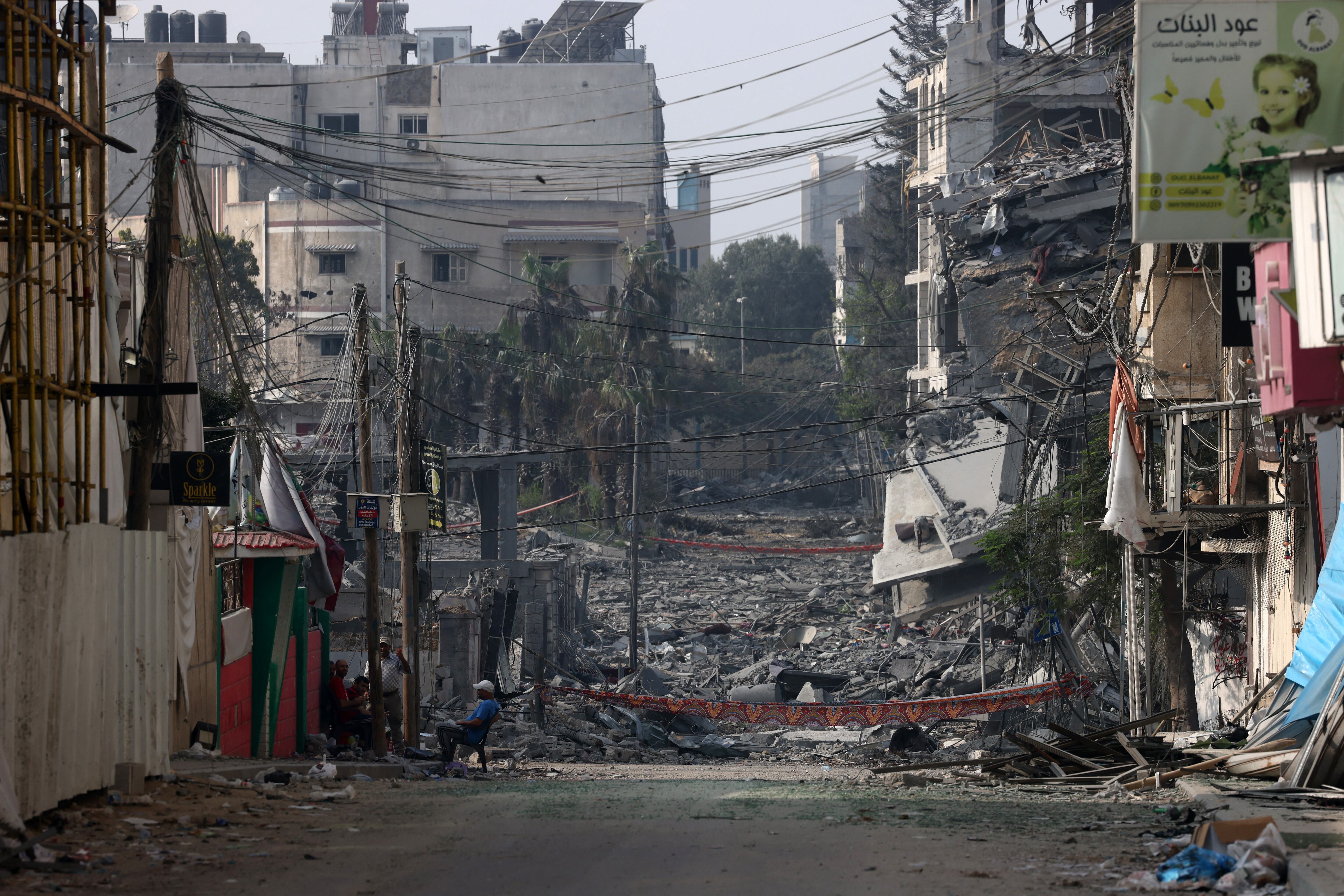 Un hombre sentado frente a edificios destruidos por ataques israelíes en la ciudad de Gaza el 28 de octubre de 2023. (Foto de MOHAMMED ABED / AFP)