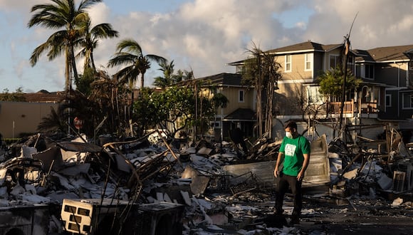 Un voluntario de Mercy Worldwide evalúa los daños de un complejo de apartamentos calcinados después de un incendio forestal en Lahaina, en el oeste de Maui, Hawái, el 12 de agosto de 2023. (Foto de Yuki IWAMURA / AFP)