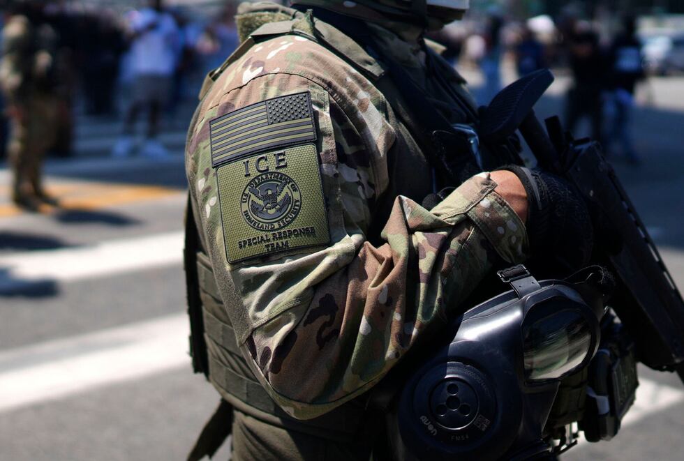 Un miembro del Equipo de Respuesta Especial de ICE monta guardia frente al Centro de Detención Metropolitano, mientras manifestantes se congregan afuera para denunciar las operaciones de ICE, el martes 10 de junio de 2025, en el centro de Los Ángeles. | Crédito: Eric Thayer / AP