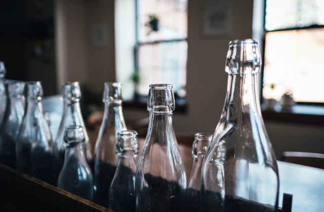 Botellas de vidrio alineadas en una repisa (Foto: Andrew Seaman/Unsplash)