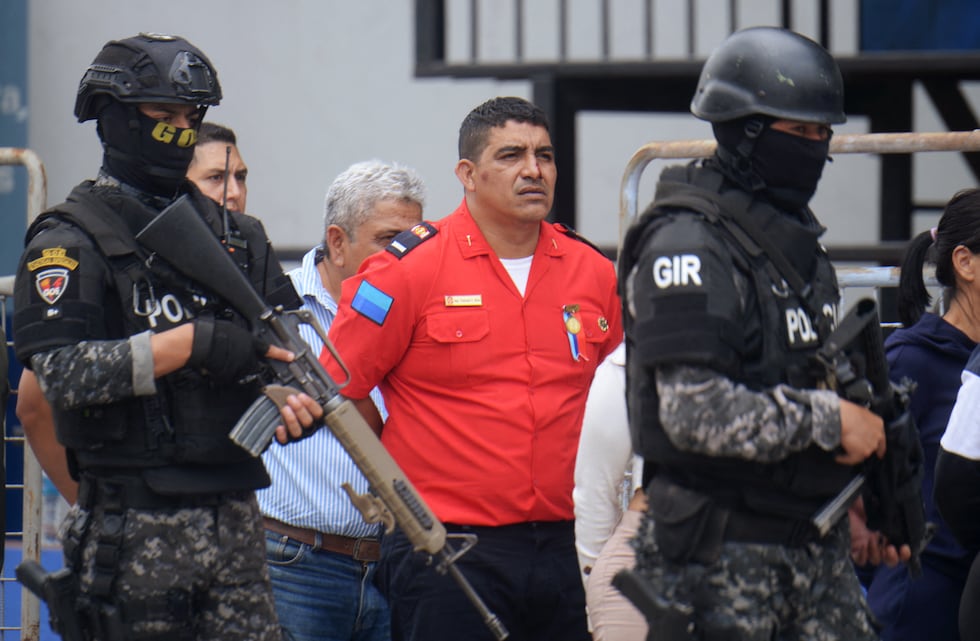 Presuntos miembros de la banda criminal Chone Killers son escoltados por agentes de policía después de ser arrestados en Durán, Ecuador, el 14 de agosto de 2024.(Foto de Gerardo MENOSCAL/AFP).