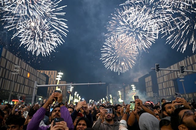La gente observa los fuegos artificiales iluminar el cielo durante las celebraciones de Año Nuevo en Lusail, Qatar, el 1 de enero de 2026. (Foto de MAHMUD HAMS / AFP)