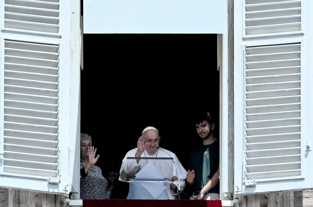 El papa Francisco, junto a una abuela y un nieto, aparece en la ventana del palacio apostólico con vista a la plaza de San Pedro durante la oración del Ángelus, en el Vaticano el 23 de julio de 2023. (Foto de Tiziana FABI / AFP)