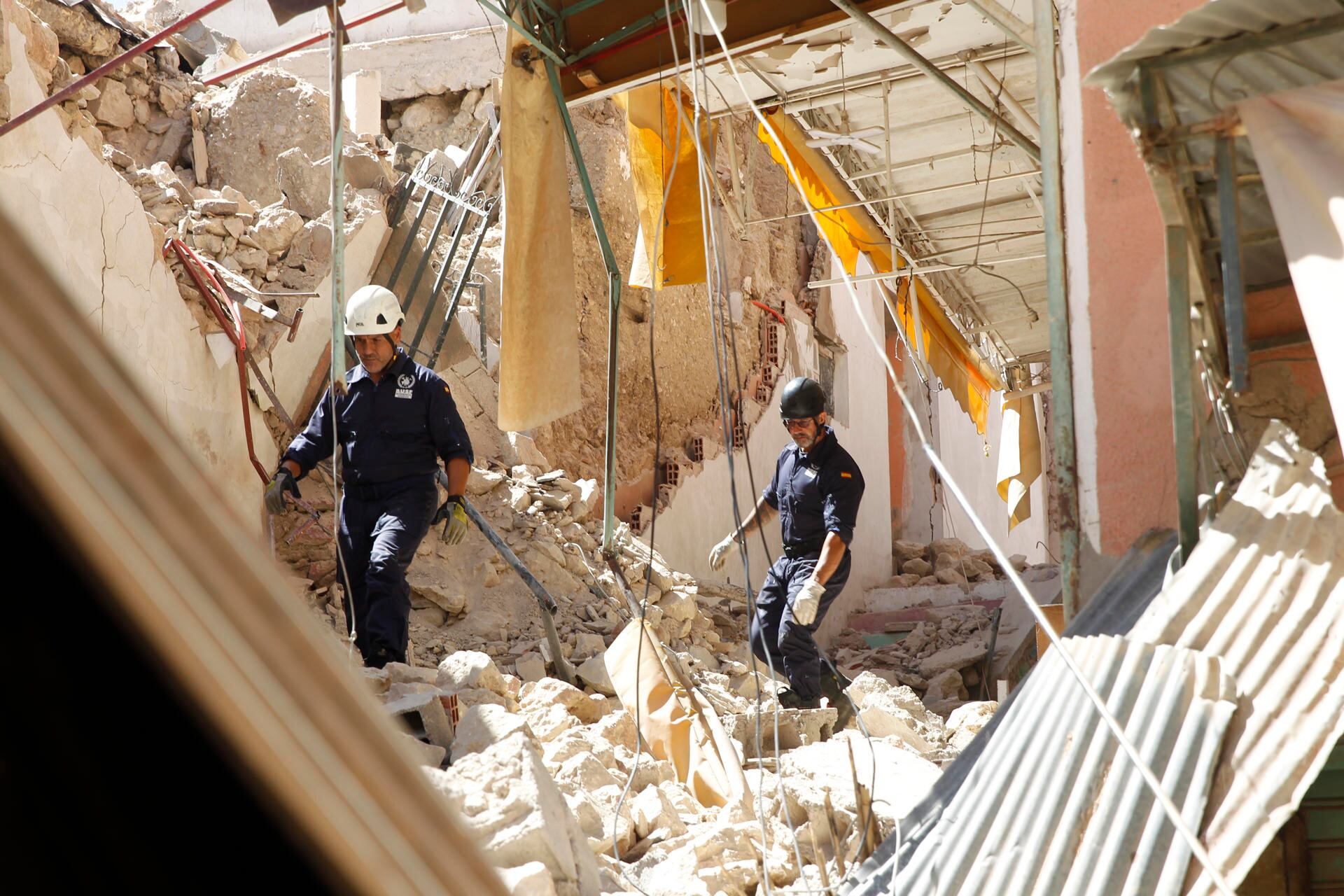 Miembros españoles de Bomberos Unidos sin Fronteras inspeccionan las ruinas de un edificio en la localidad de Mulay Ibrahim, a 55 kilómetros al sur de Marrakech. (EFE/Maria Traspaderne).