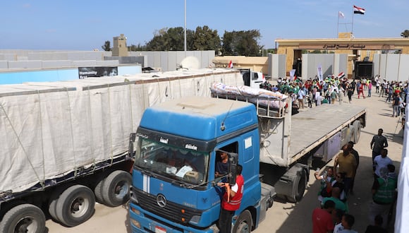 Un camión de ayuda es recibido por trabajadores humanitarios al cruzar de regreso a Egipto a través del cruce fronterizo de Rafah con la Franja de Gaza el 21 de octubre de 2023. (Foto de Kerolos Salah / AFP)