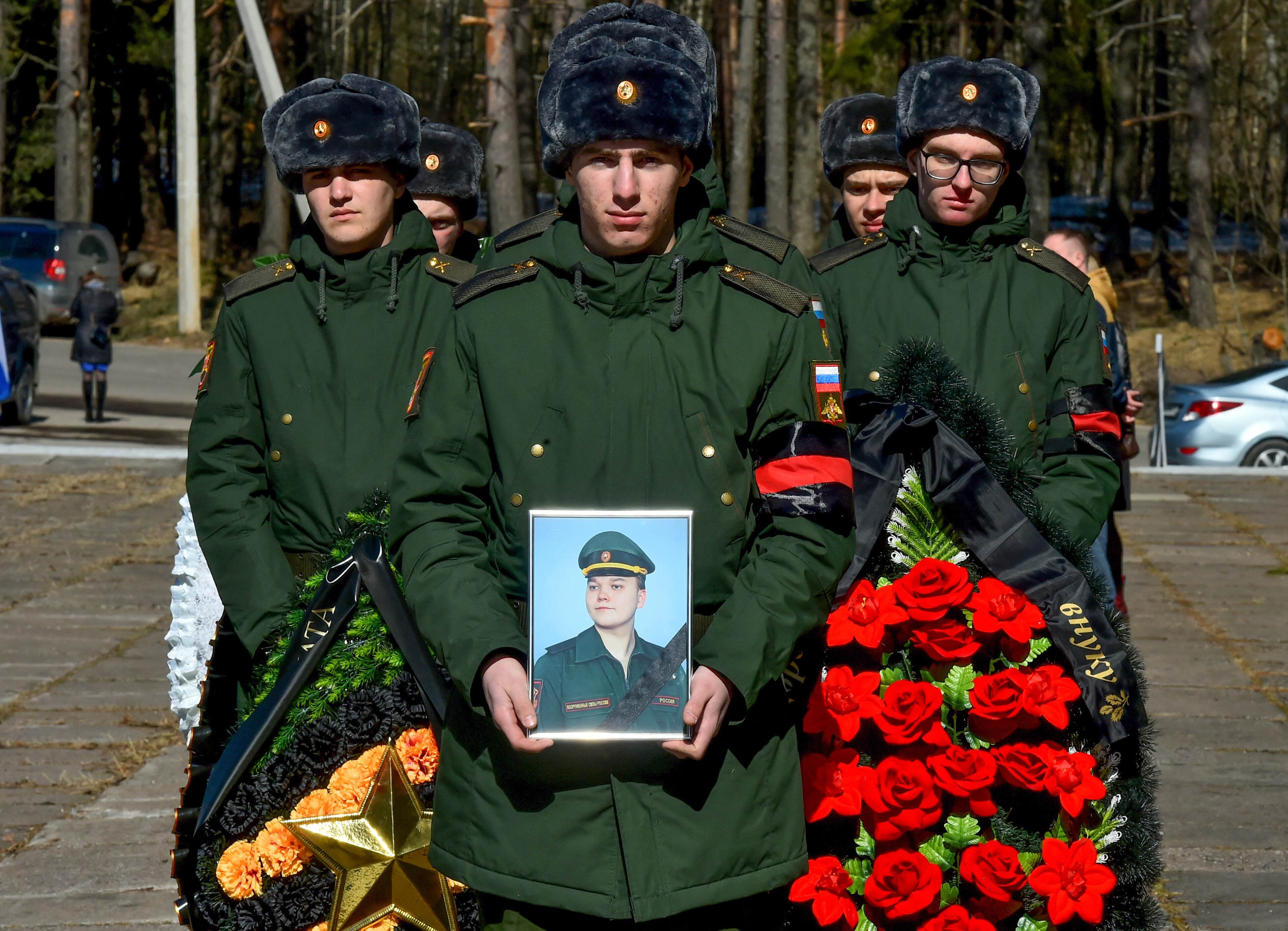 Soldados rusos llevan coronas y una foto del militar ruso Nikita Avrov, de 20 años, muerto en combate en Ucrania. (Foto: AFP).