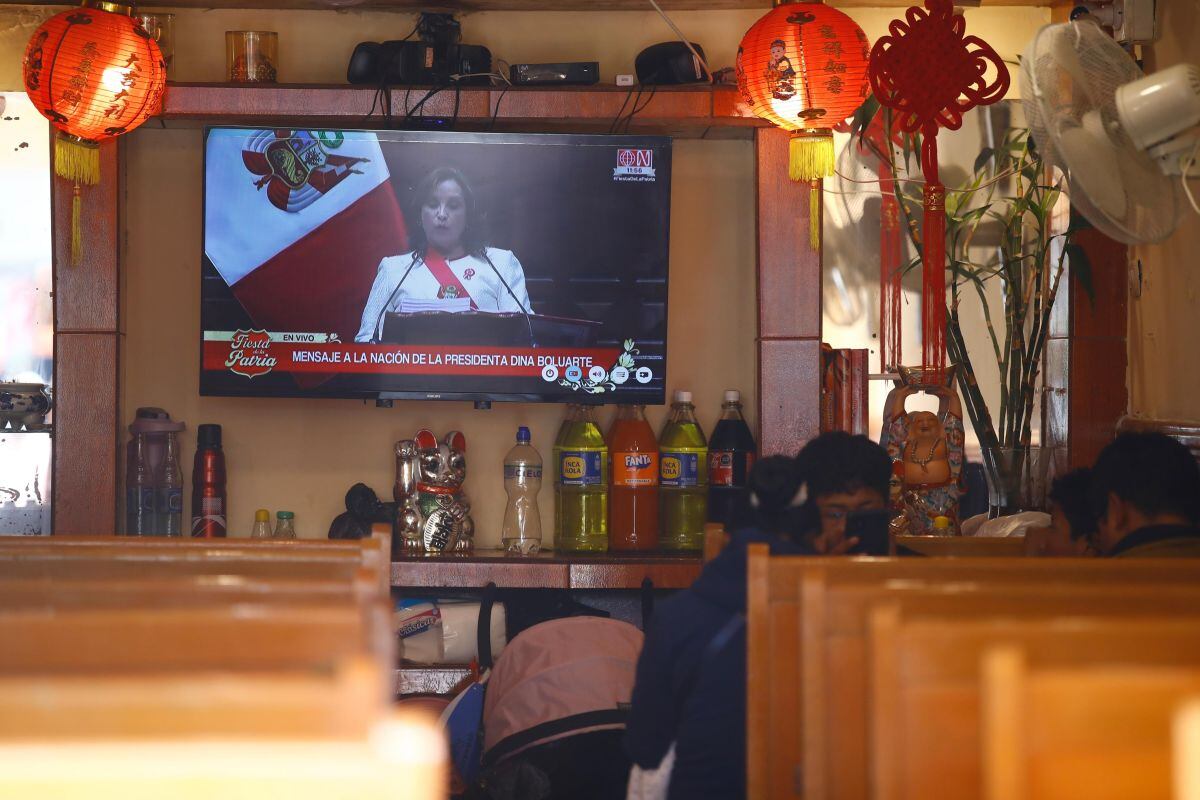 Clientes almuerzan mientras en la pantalla Dina Boluarte ofrece su último discurso como presidenta. (Foto: GEC)