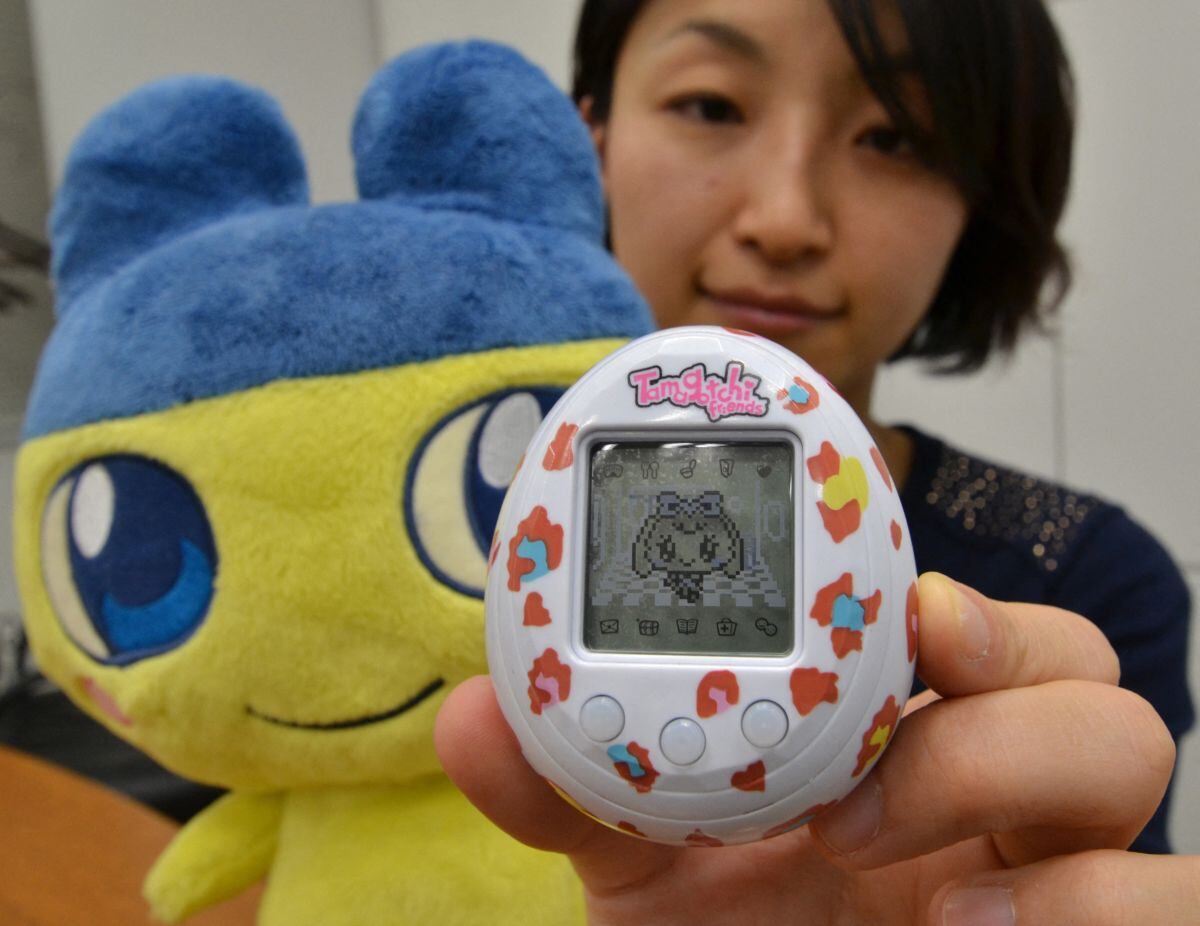 Un empleado de Bandai con un Tamagtochi. (Foto: AFP)