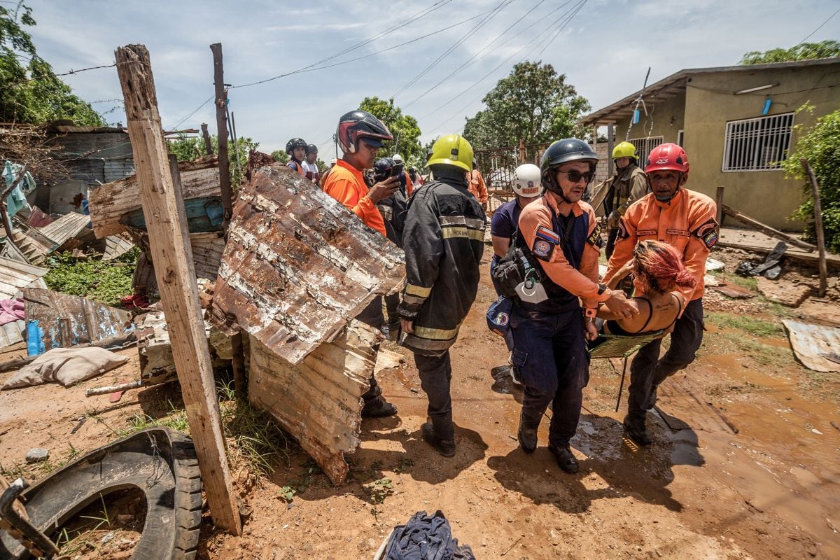 Miembros de la Defensa Civil trasladan a una mujer herida tras una explosión en una fábrica de fuegos artificiales en el municipio de San Francisco, estado de Zulia, Venezuela, el 11 de septiembre de 2025. Foto: Alejandro Paredes / AFP
