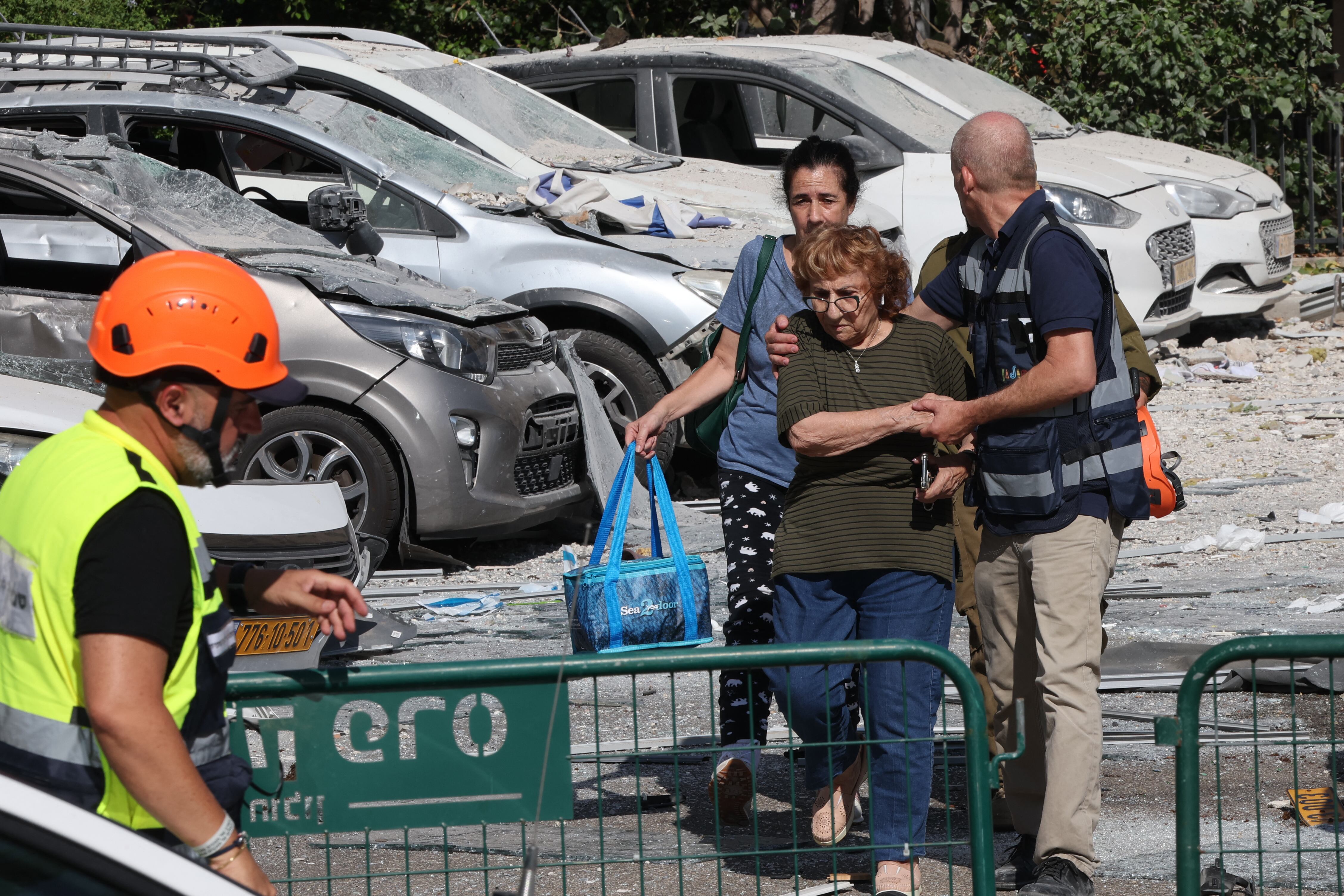 Civiles caminan por una zona residencial alcanzada por un ataque con misiles iraníes en Holon, en el centro de Israel, el 19 de junio de 2025. (Foto de Jack GUEZ / AFP).