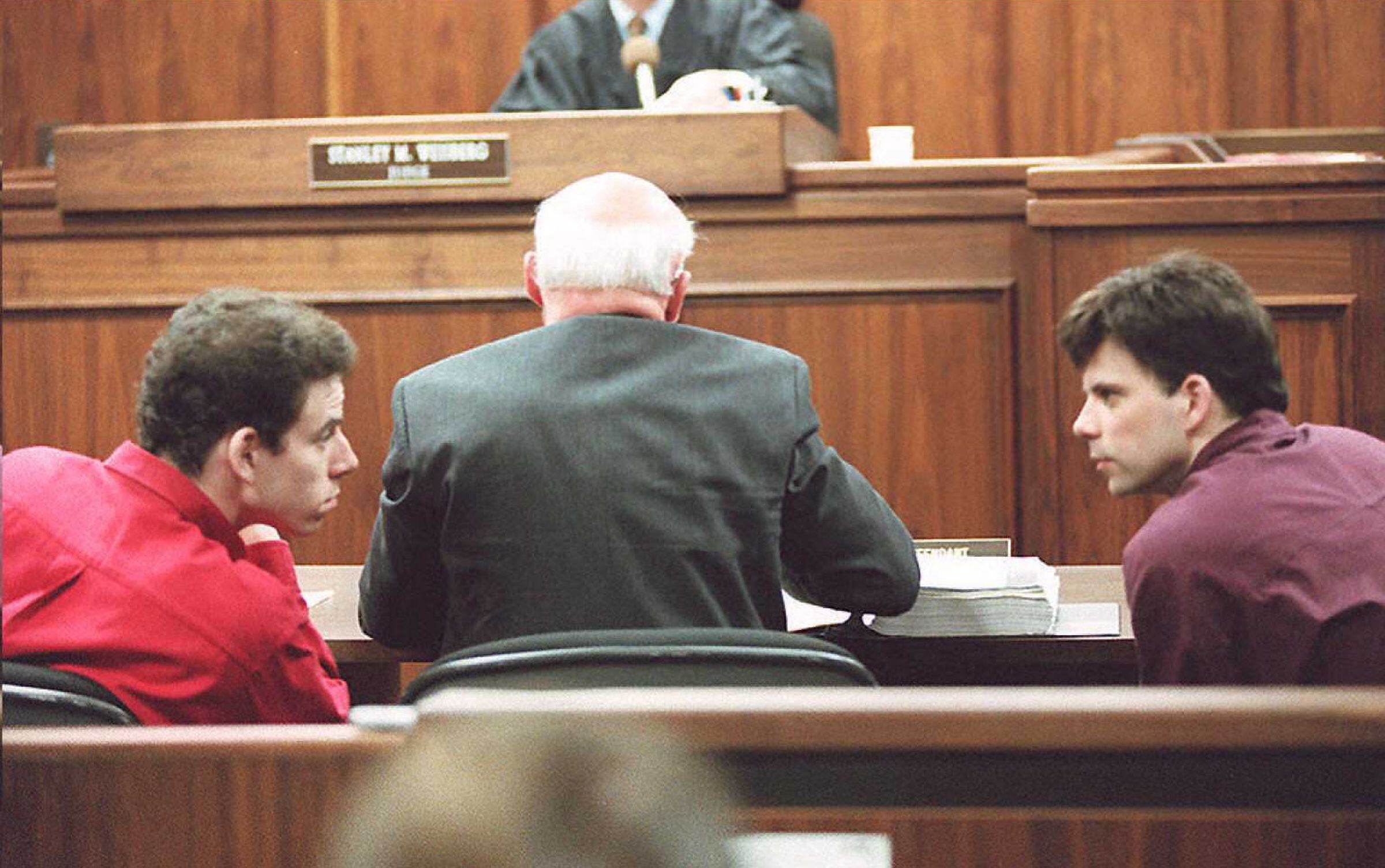 Erik (izq.) y Lyle (der.) Menéndez conversan en la sala del tribunal durante una audiencia en Los Ángeles, en esta fotografía de archivo del 2 de febrero de 1995 (Foto: AFP)