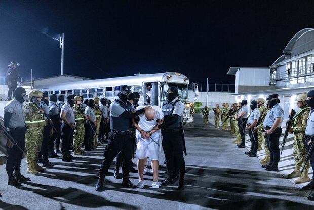 Custodios del Centro del Confinamiento del Terrorismo (CECOT), trasladando a un grupo de detenidos provenientes de Estados Unidos, en Tecoluca, El Salvador, el 31 de marzo de 2025. (Foto de Gobierno de El Salvador / EFE)