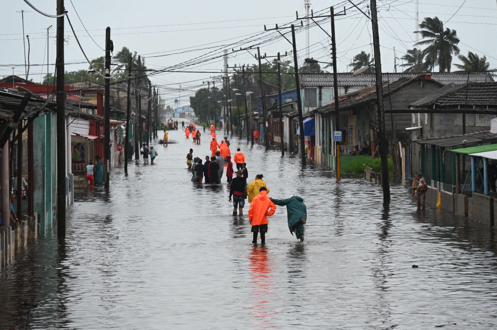 La gente camina por una calle inundada en Batabano, provincia de Mayabeque, Cuba, el 29 de agosto de 2023, durante el paso del huracán Idalia. (Foto de Yamil LAGE / AFP).