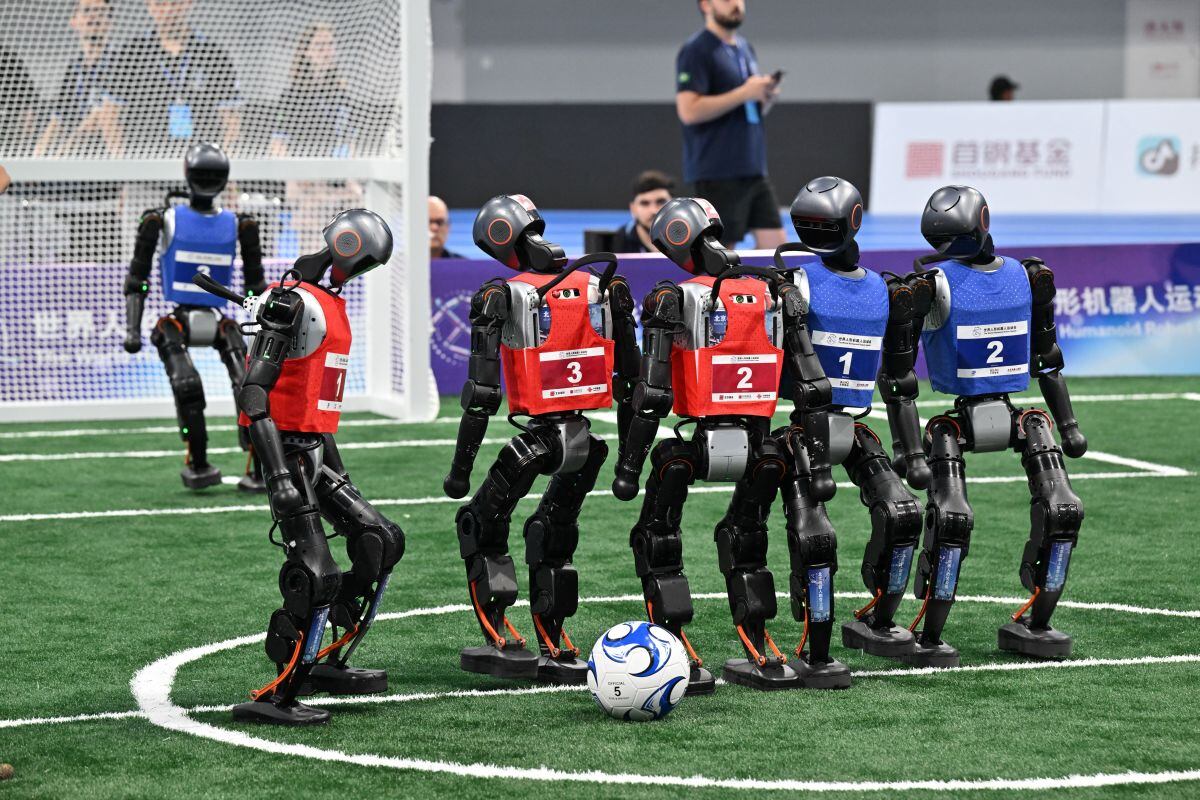 Robots compiten en un partido de fútbol 3x3 durante los Juegos mundiales de robots humanoides en Pekín el 15 de agosto de 2025.